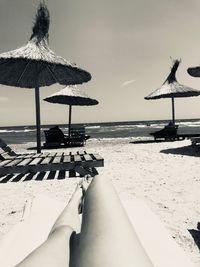 Traditional windmill on beach against sky