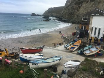 Boats moored on beach against sky