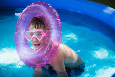 Portrait of shirtless boy swimming in pool