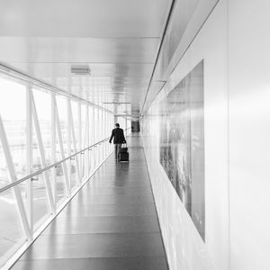 Rear view of businessman walking in airport terminal