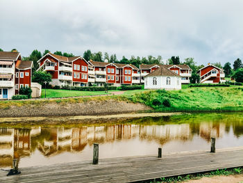 Buildings by lake against sky