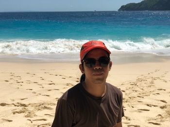 Portrait of man wearing sunglasses on beach