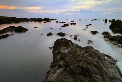 Scenic view of rocks against sky during sunset