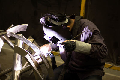 Man welding metal at factory