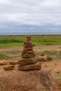 Stack of rocks on shore against sky