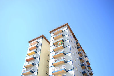 Low angle view of buildings against clear blue sky