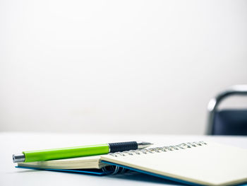 Close-up of pen on table against white background