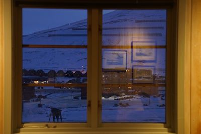 Buildings seen through glass window during winter