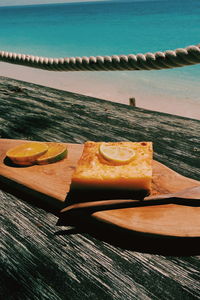 Close-up of cake on table against sea