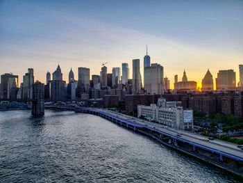 Modern buildings in city against sky during sunset