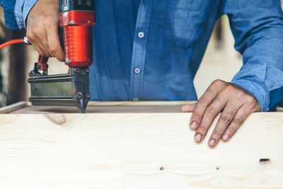 Midsection of man working on cutting board