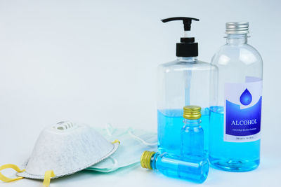 Close-up of bottles on table against white background