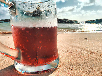 Close-up of drink in glass on beach
