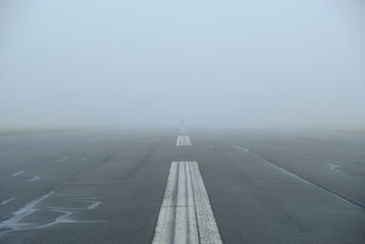 Airplane on runway against sky during winter