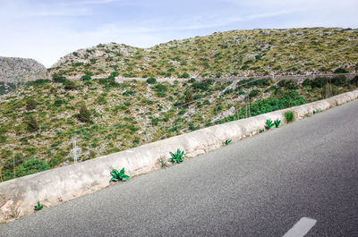 People on road by mountain against sky