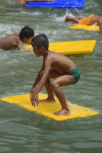 Shirtless boys playing in lake