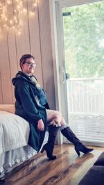 Young woman sitting on a window at home