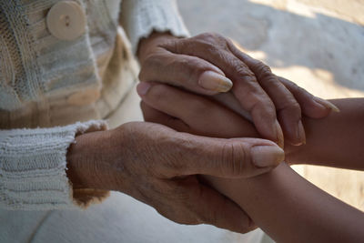 Midsection of couple holding hands