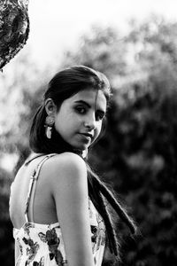 Portrait of young woman standing on field