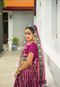 Portrait asian woman in a margenta indian tradition sari, she is looking at a camera 