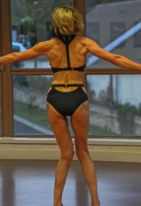 Rear view of mature woman wearing bikini while standing at home