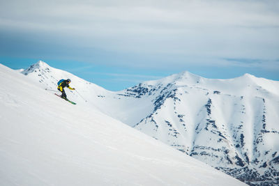 A man skiing with mountains behind him in iceland