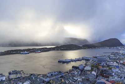 High angle view of town by sea against sky