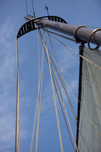 Low angle view of sailboat against blue sky