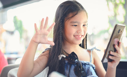 Portrait of happy girl with mobile phone