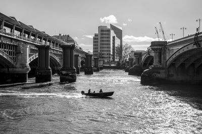 Boats in river with buildings in background