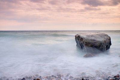 Romantic atmosphere in peaceful morning at sea. big boulders sticking out from smooth wavy sea