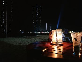 Illuminated table against sky at night