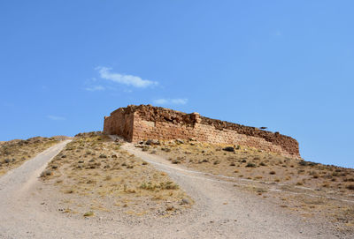Low angle view of old ruin building against blue sky