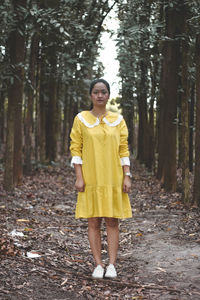 Portrait of woman standing in forest