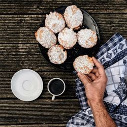 Cropped image of hand holding cookie during breakfast