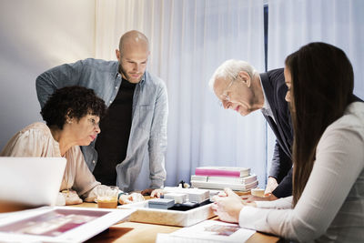 Business team discussing over model in board room