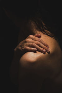 Rear view of a woman hand against black background