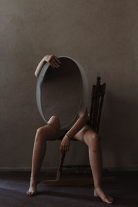Midsection of woman sitting on wall