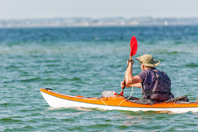 Rear view of man in kayak on sea