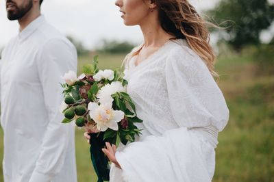 Newlywed couple walking on field