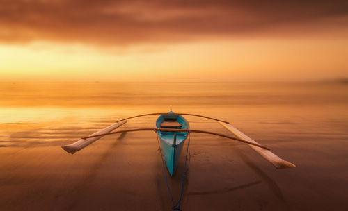 Boat on sea against sky during sunset