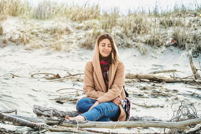 Portrait of young woman sitting on rock