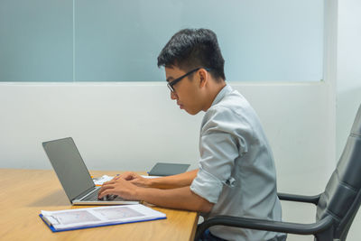 Young man using laptop at office