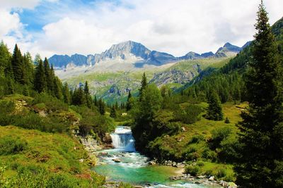 Scenic view of river and mountains against sky