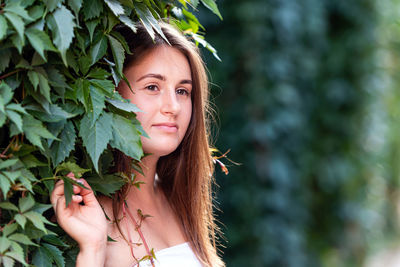 Close-up of young woman by leaves