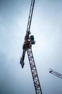 Low angle view of crane against sky