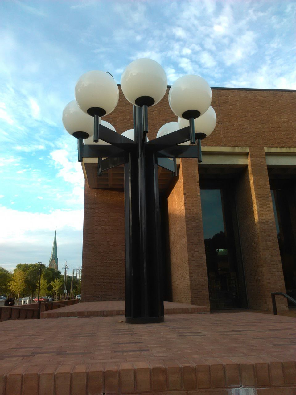 architecture, built structure, building exterior, sky, low angle view, street light, cloud - sky, lighting equipment, cloud, sunlight, day, outdoors, no people, architectural column, building, tree, city, cloudy, window, lamp post