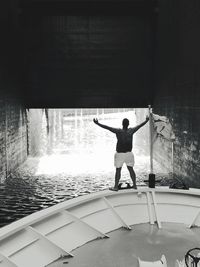 Rear view of man standing on boat