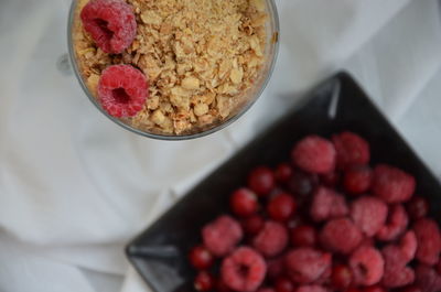High angle view of breakfast cereal and raspberry in bowl