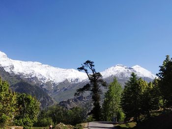 Scenic view of snowcapped mountains against clear blue sky